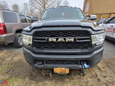 Ram 3500 pickup truck front view showing large grille with RAM lettering and NY license plate, plow hitch area visible.