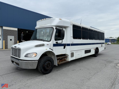 Used 2018 Freightliner S2106 wheelchair bus in white with blue stripe, front hood, passenger entry, large bus windows, parked outside a blue-roofed building.