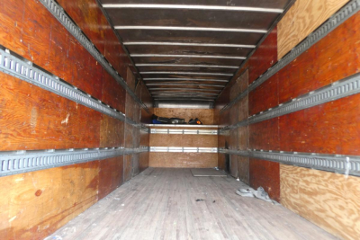 Truck box interior showing empty cargo space with wooden side walls and metal tracks