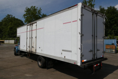Box truck rear and side view showing large white cargo box with doors and rear light bars.