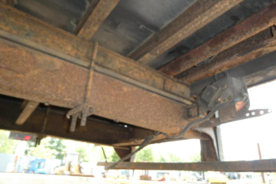 Truck underside showing frame rails and hitch portion with rust patina.
