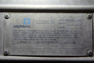 Truck identification plate with Morgan logo and VIN; plate shows date manufactured, month/year, serial no., model no., and stock number.