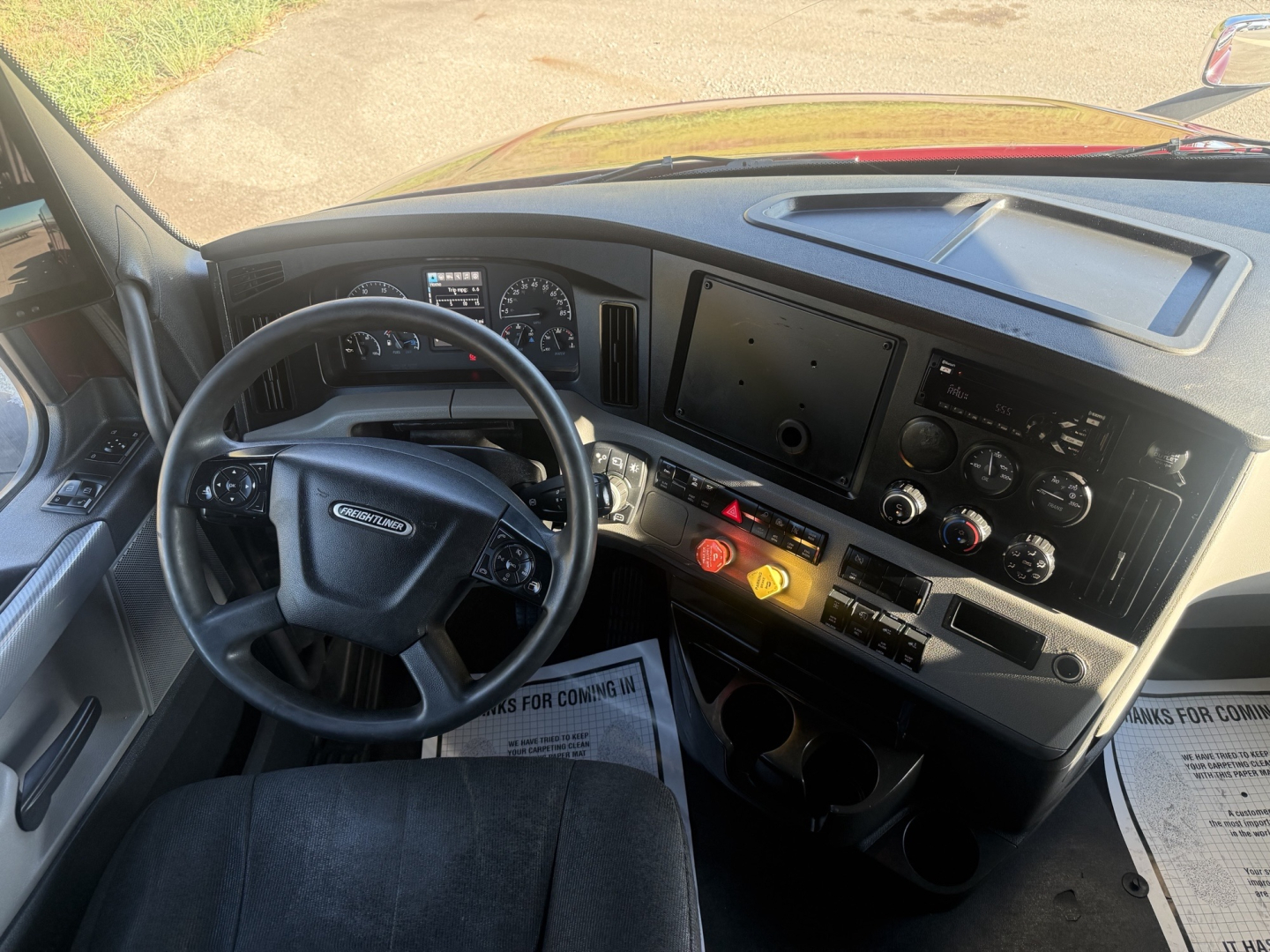 Freightliner Cascadia126 truck cabin interior showing steering wheel, dashboard with gauges, center infotainment screen, and control panel.