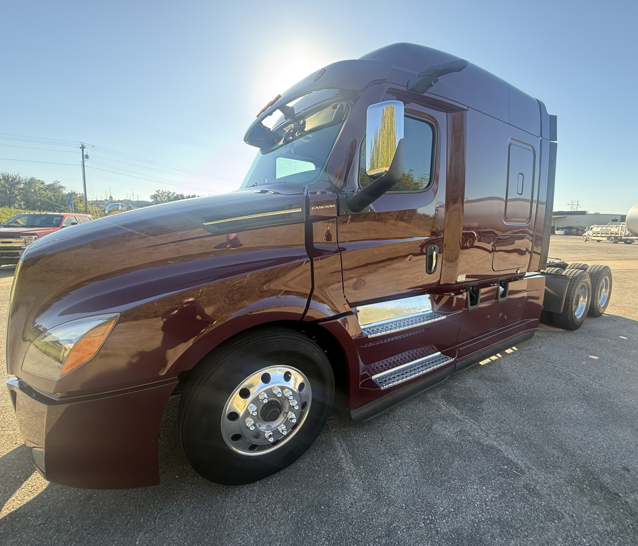 Freightliner Cascadia126 truck cab in side view showing door, chrome steps, and large front fender with wheel