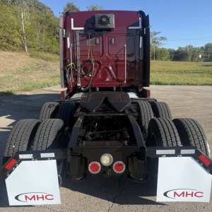 Freightliner Cascadia 126 tractor rear view showing chassis, mud flaps with MHC logos, and rear lighting.