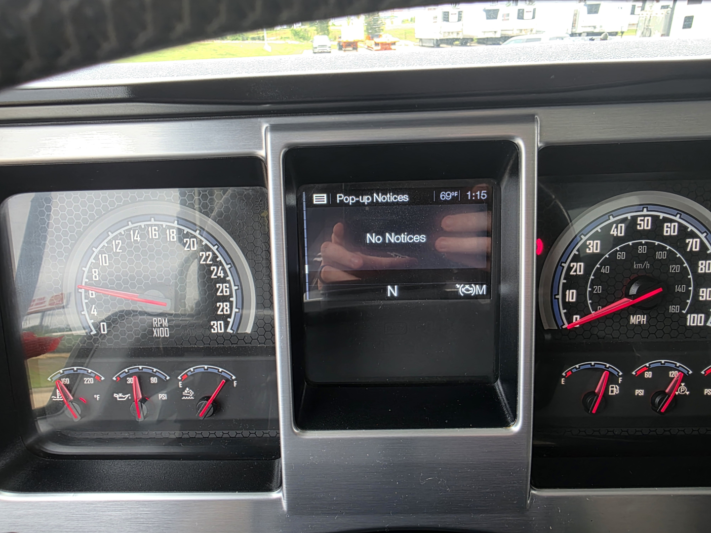 Dashboard view of a 2021 Mack Granite truck showing gauges and a central display with 'Pop-up Notices' screen, no notices visible, instrument cluster includes speedometer and tachometer.