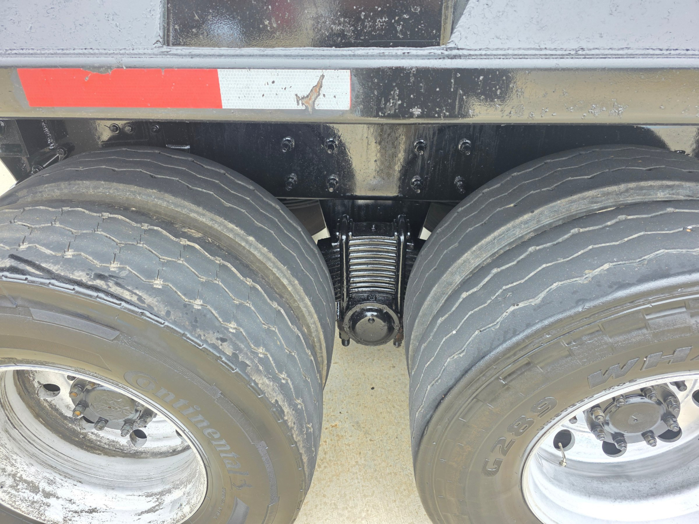 Mack Granite dump truck dual rear wheels showing suspension and axle area with coil spring
