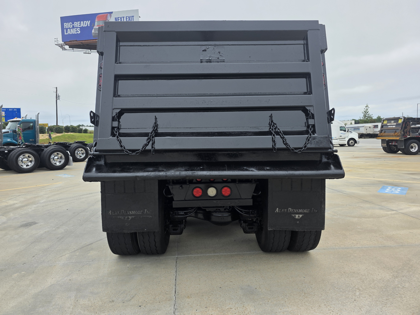 Dump truck bed of a 2021 Mack Granite viewed from the rear, with hydraulic dump mechanism and tailgate chains visible.