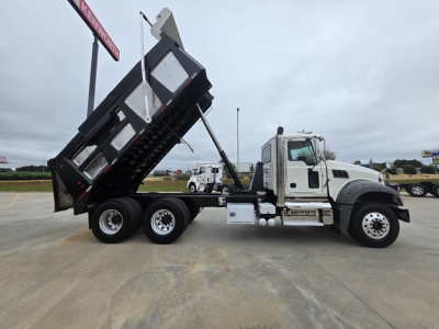 Truck side view of 2021 Mack GRANITE dump truck with raised bed and multiple axles.