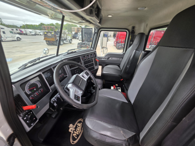 Cab interior of a 2021 Mack Granite dump truck showing steering wheel, dashboard, and two front seats.