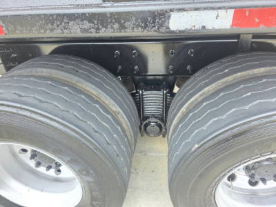 Rear view of a Mack GRANITE truck chassis showing dual rear axles with heavy tires and suspension components.
