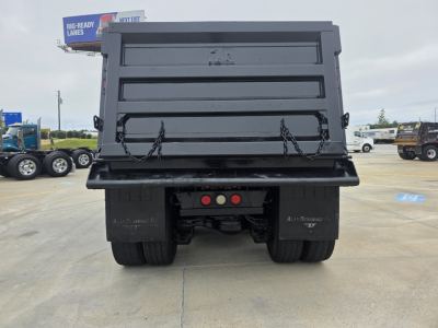 Dump truck bed of a 2021 Mack Granite viewed from the rear, with hydraulic dump mechanism and tailgate chains visible.