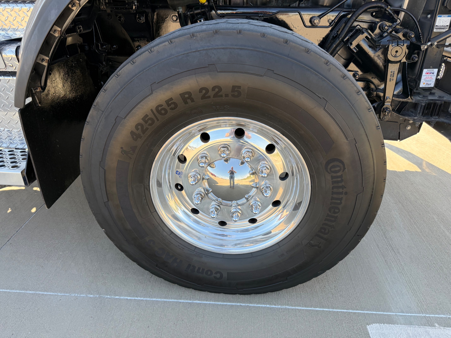 Kenworth truck front wheel showing Continental tire marked 425/65 R22.5 and chrome hub with lug nuts.