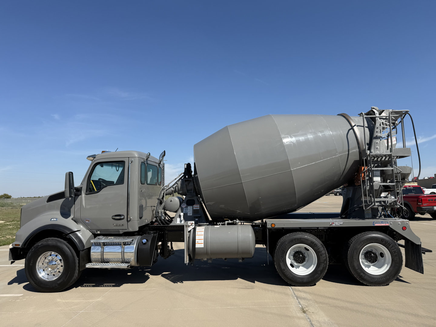 Kenworth mixer truck in profile view showing concrete mixer drum and cab with stock number 0633128.