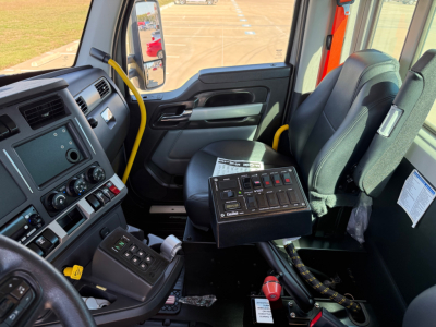 Kenworth T880 mixer truck cab interior with steering wheel, dashboard, and center console controls; visible gear shifter and control panel.