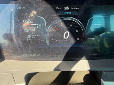 Kenworth T880 dashboard display showing speedometer at 0 MPH with digital readouts and warning icons in a mixer truck cockpit.