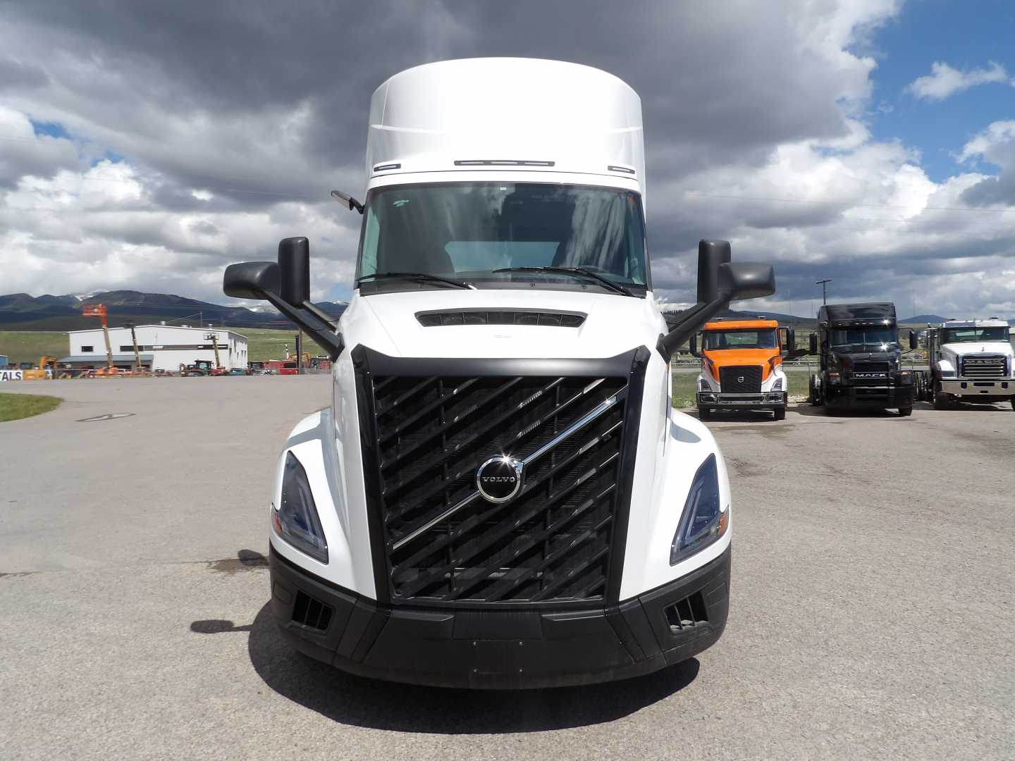 Front view of a white 2025 Volvo VNL64T300 daycab truck showing large black grille, headlights, and Volvo emblem.