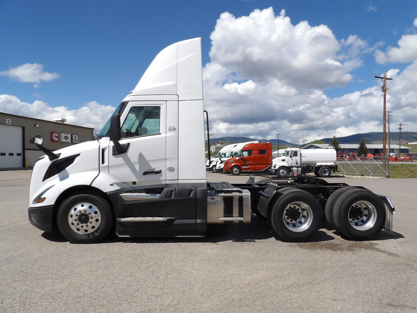 Volvo VNL64T300 tractor unit side view showing white cab and chassis, with clear view of wheels and fifth wheel area.