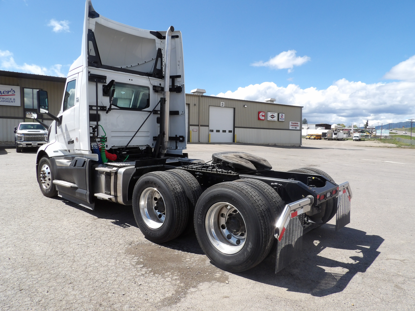 Volvo VNL64T300 truck tractor cab rear and chassis visible with dual rear axles, fuel tanks, and fifth wheel.