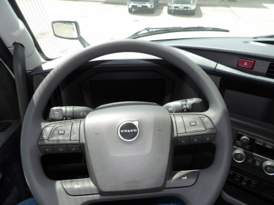 Volvo steering wheel inside cab with dashboard controls and center console visible.