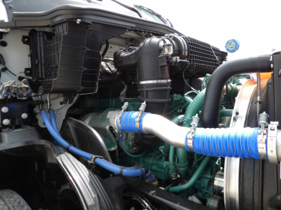 Volvo VNL64T300 engine bay showing turbo hoses and coolant pipes with blue bands and green engine block.