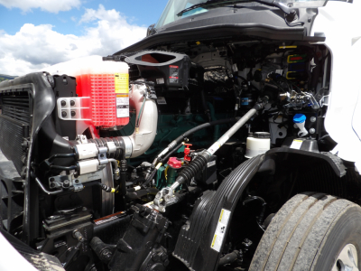 Volvo VNL64T300 engine bay showing coolant reservoir, air intake, hoses, and diesel engine components.