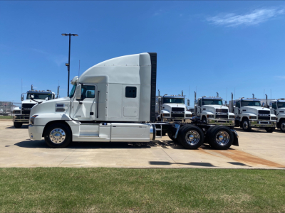 2019 Mack AN64T70 conventional sleeper truck in profile view with multiple white trucks in background.