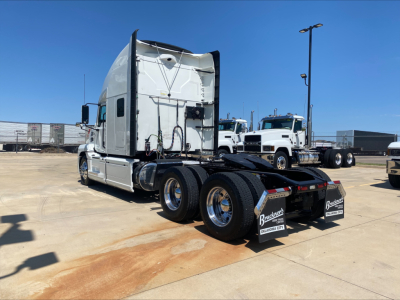 2019 Mack AN64T70 semi tractor cab from rear-left view showing fuel/tank area, rear dual axles, mud flaps with Bracken logo, and basic under-cab components.