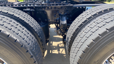 Mack AN64T70 truck rear wheels and drivetrain seen from between tandem axles, showing suspension and drive components.