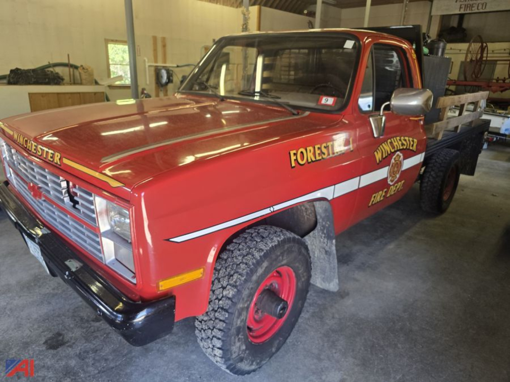 1986 Chevrolet CUCV CD-30903 M1028 1-ton flatbed truck in red, forestry livery, front three-quarter view showing 'FOREST' and 'WINCHESTER' text, vintage fire department markings.