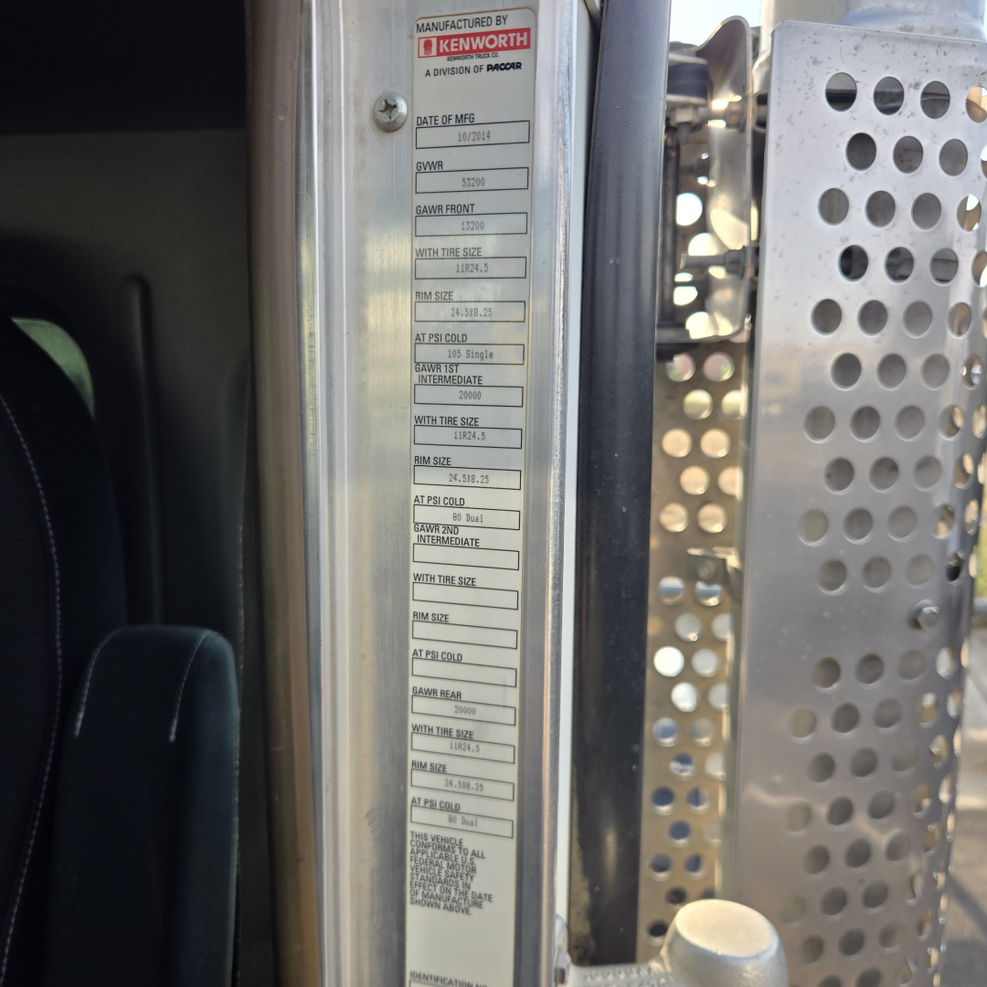 Kenworth T800 cab area showing manufacturer label with VIN and specifications on door jamb and perforated metal step cover.