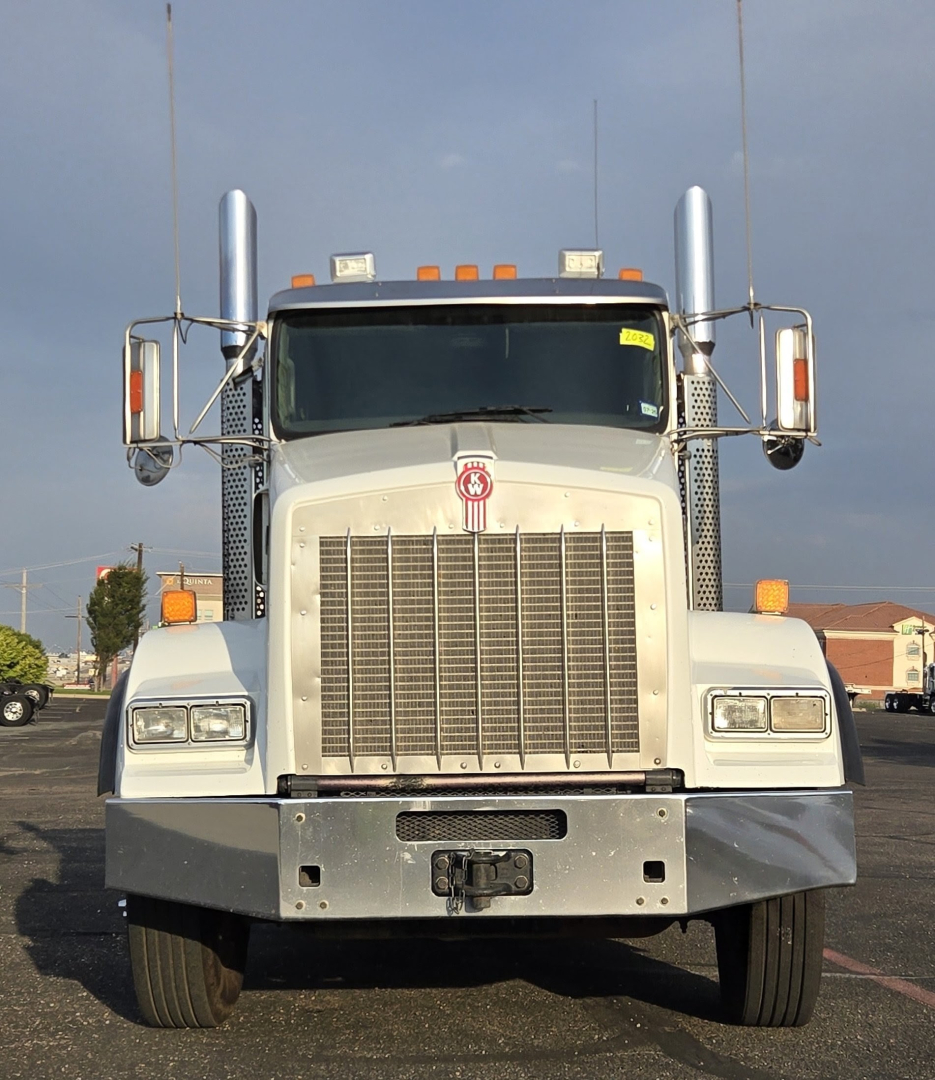 Kenworth T800 front view showing large grille, rectangular headlights, chrome bumper, dual exhaust stacks, and side mirrors.