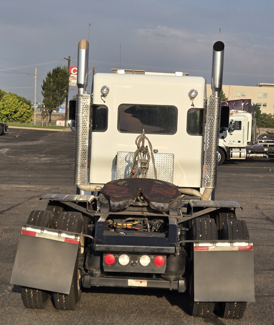 Kenworth T800 rear view showing fifth wheel, dual exhaust stacks, and rear lights.