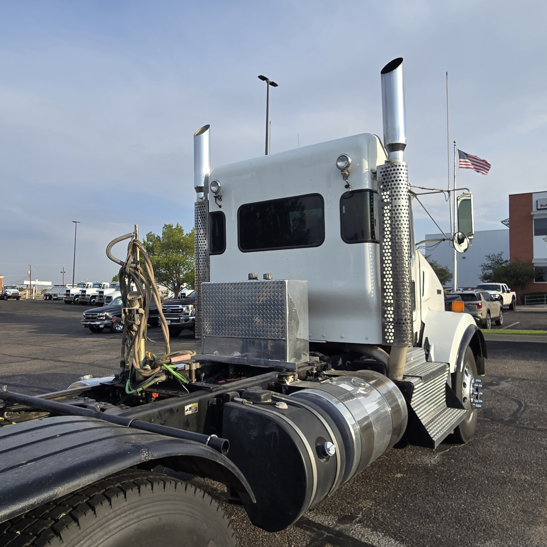 Kenworth T800 sleeper cab tractor rear view showing exhaust stacks and fuel tanks, with chrome aluminum diamond-plate toolbox and exposed routing harnesses.