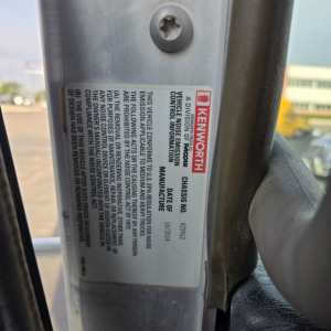 Kenworth truck door sticker with model and VIN information visible on the frame. The label includes 'KENWORTH', and vehicle identification details.