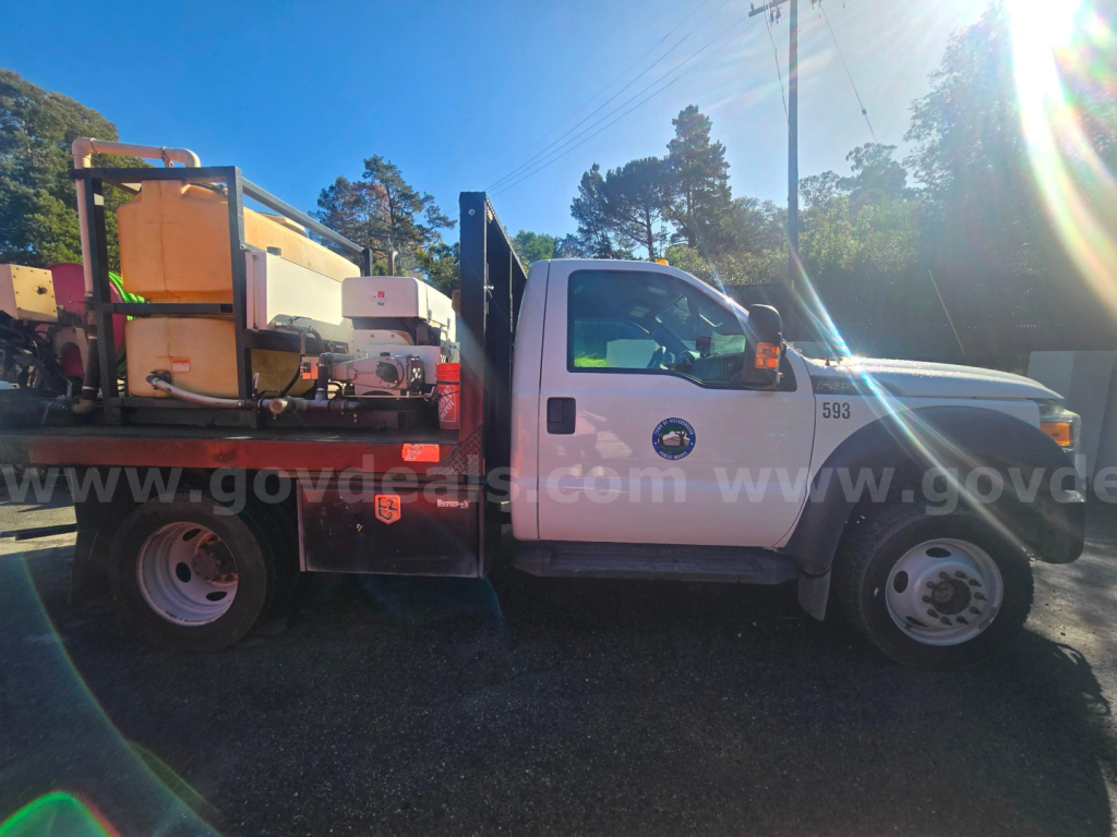 Ford F-450 truck side view showing utility body with equipment and tanks.