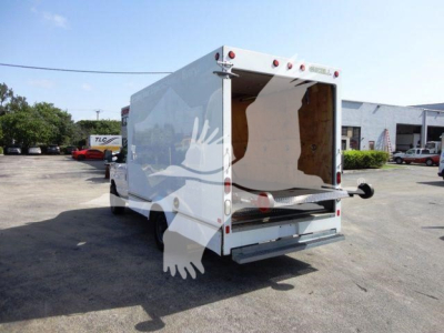 Ford E-350 cargo box rear view showing white box truck with open rear doors and wooden interior, undercarriage and tailgate visible.