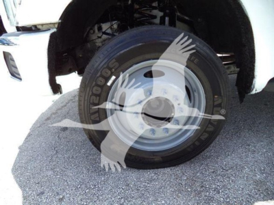Ford F-550 front wheel and tire assembly with steel rim, visible suspension components.