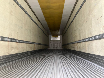 Interior of a 2012 refrigerated trailer with ribbed metal floor and yellow ceiling beam visible at far end.