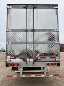 Trailer rear view of a 2012 Utility Reefer with diamond-plate aluminum doors, dual doors, rear lights, bumper, and reflective tape.