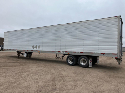 Trailer side view of a 2012 Utility reefer refrigerated trailer with a long aluminum exterior and dual rear axles.