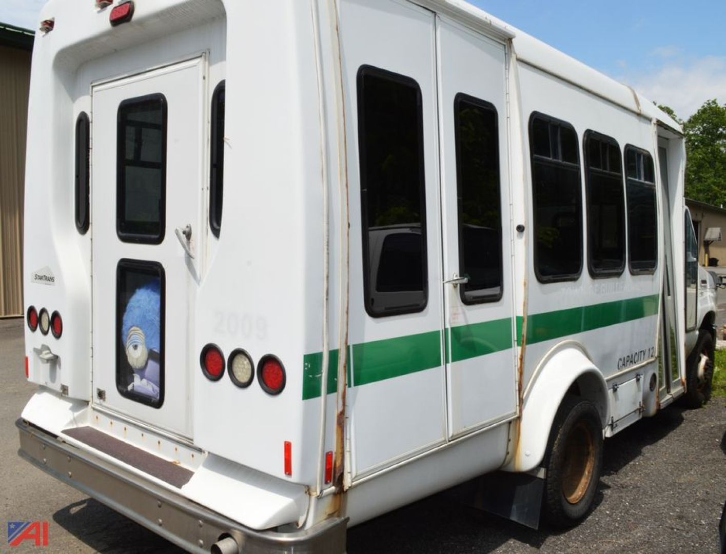 Ford E350 bus rear view showing wheelchair bus with green stripe and multiple side windows.