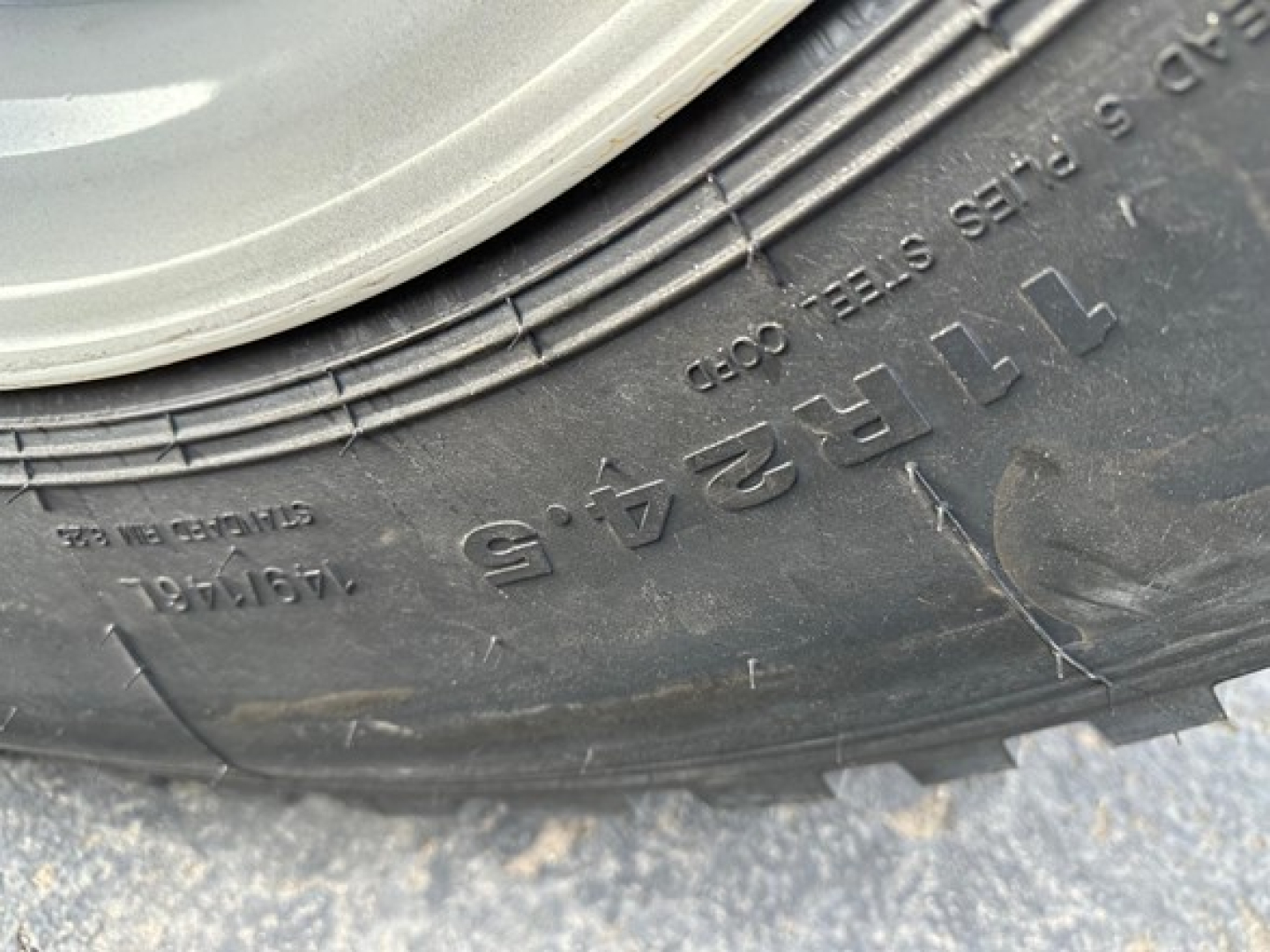Close-up of tire wall showing brand markings and numbers: 18x16? and series of letters/numbers on tread: 'TIRE 684 6 4' plus raised ridges.