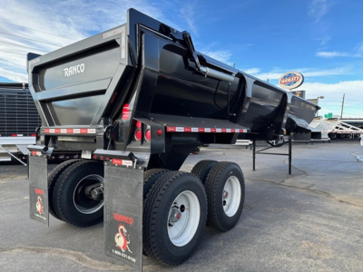 Ranco ED26-34 dump trailer in black with dual rear wheels and elevated side panels, showing hydraulic lift mechanism and reflective safety tape.