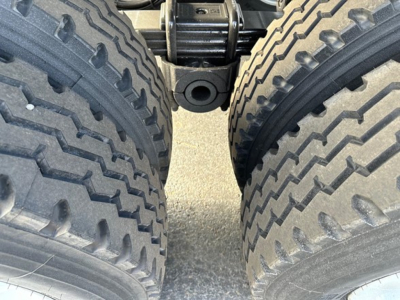 Ranco Ed26-34 trailer undercarriage view showing tandem tire setup with heavy-duty lug pattern and a mounting hitch area between wheels.