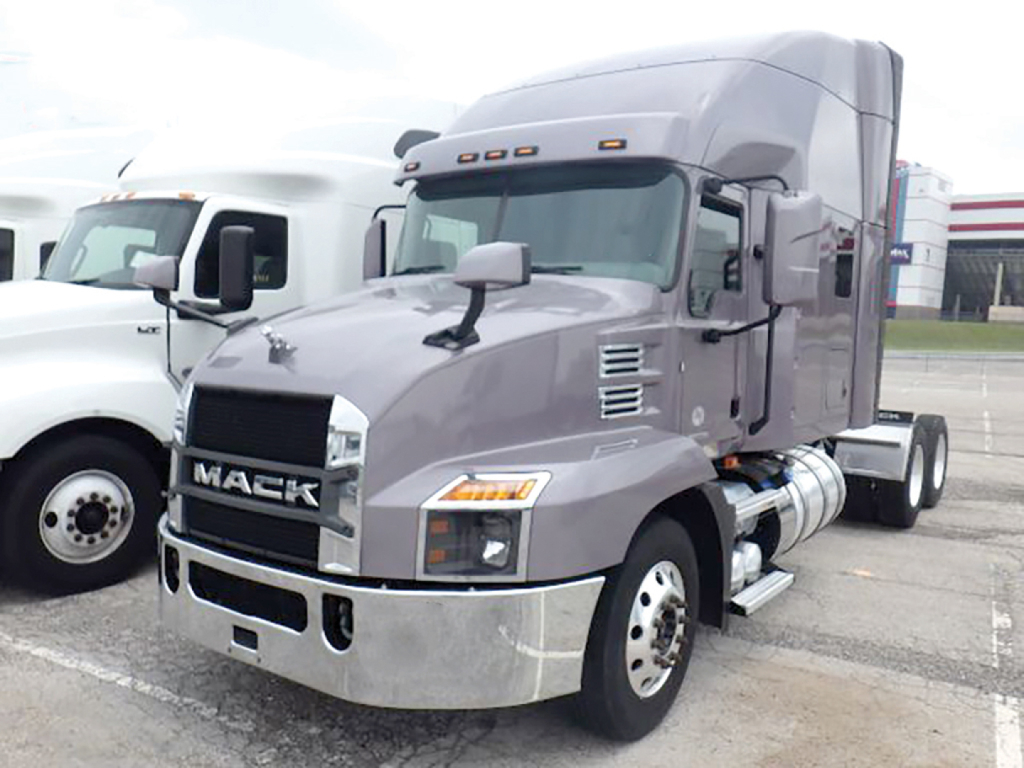 Mack Anthem truck in gray showings cab and front view with chrome bumper and side exhaust. Text on grille reads MACK.