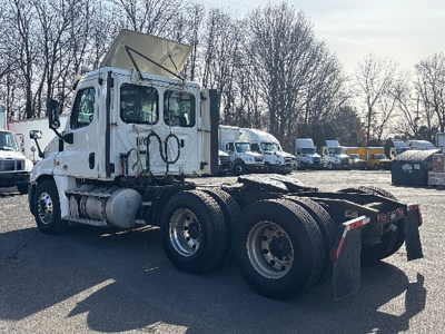 Freightliner Cascadia125 tractor cab with empty flatbed rear, side view showing dual rear axles and fifth wheel, used truck.