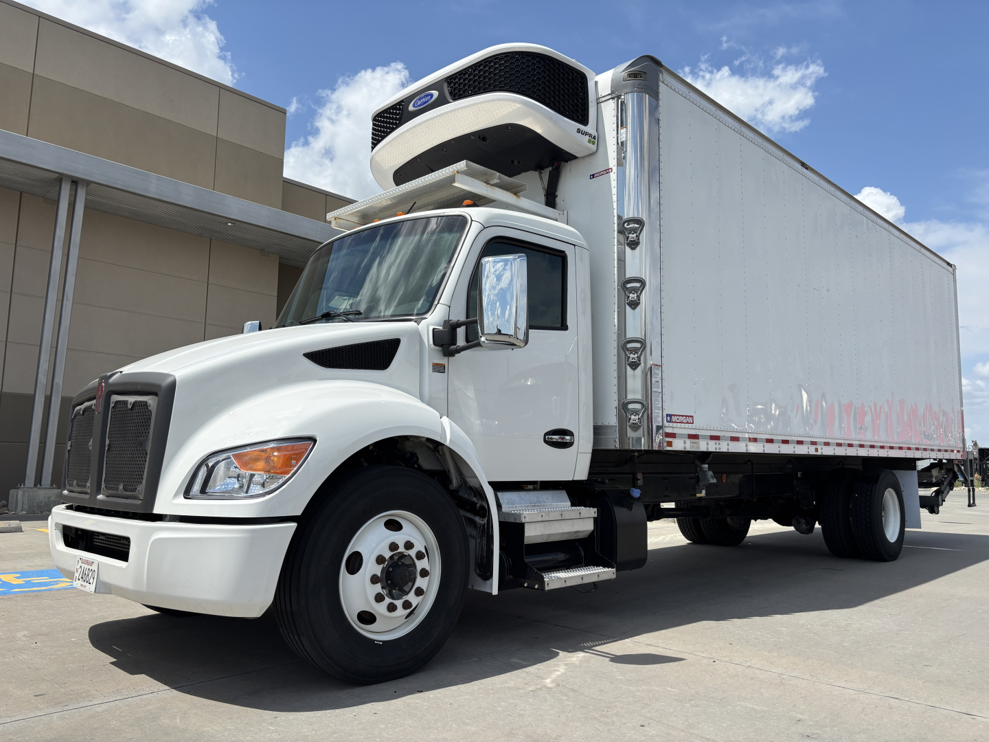 Kenworth T380 refrigerated truck with a rooftop trailer refrigeration unit and box; side view showing front wheel, cab, and cargo box.