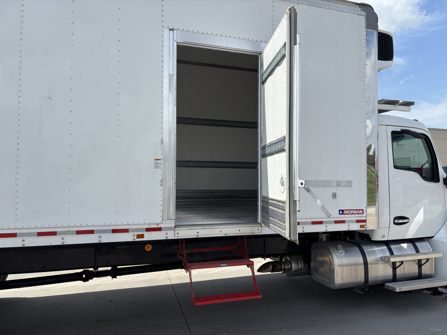 Kenworth T380 refrigerated truck side with open rear cargo area and red entry step visible