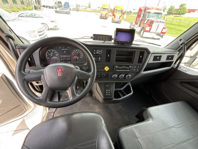 Kenworth T380 truck cab interior showing steering wheel, instrument cluster, center console, dashboard with screens and controls.